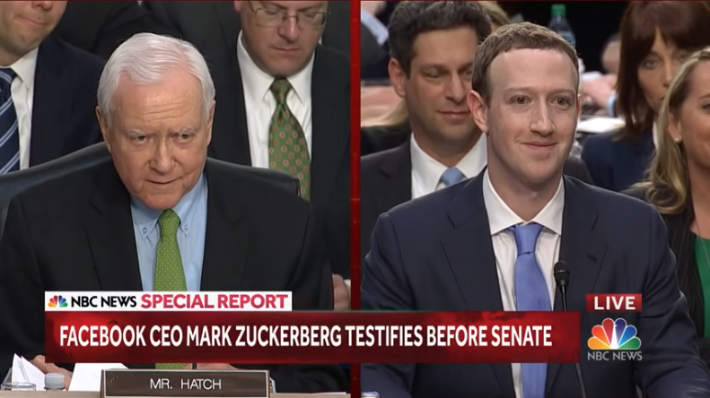 A side-by-side cable news frame with Orrin Hatch on the left and Mark Zuckerberg on the right. Zuckerbeg is smiling and Hatch is not.