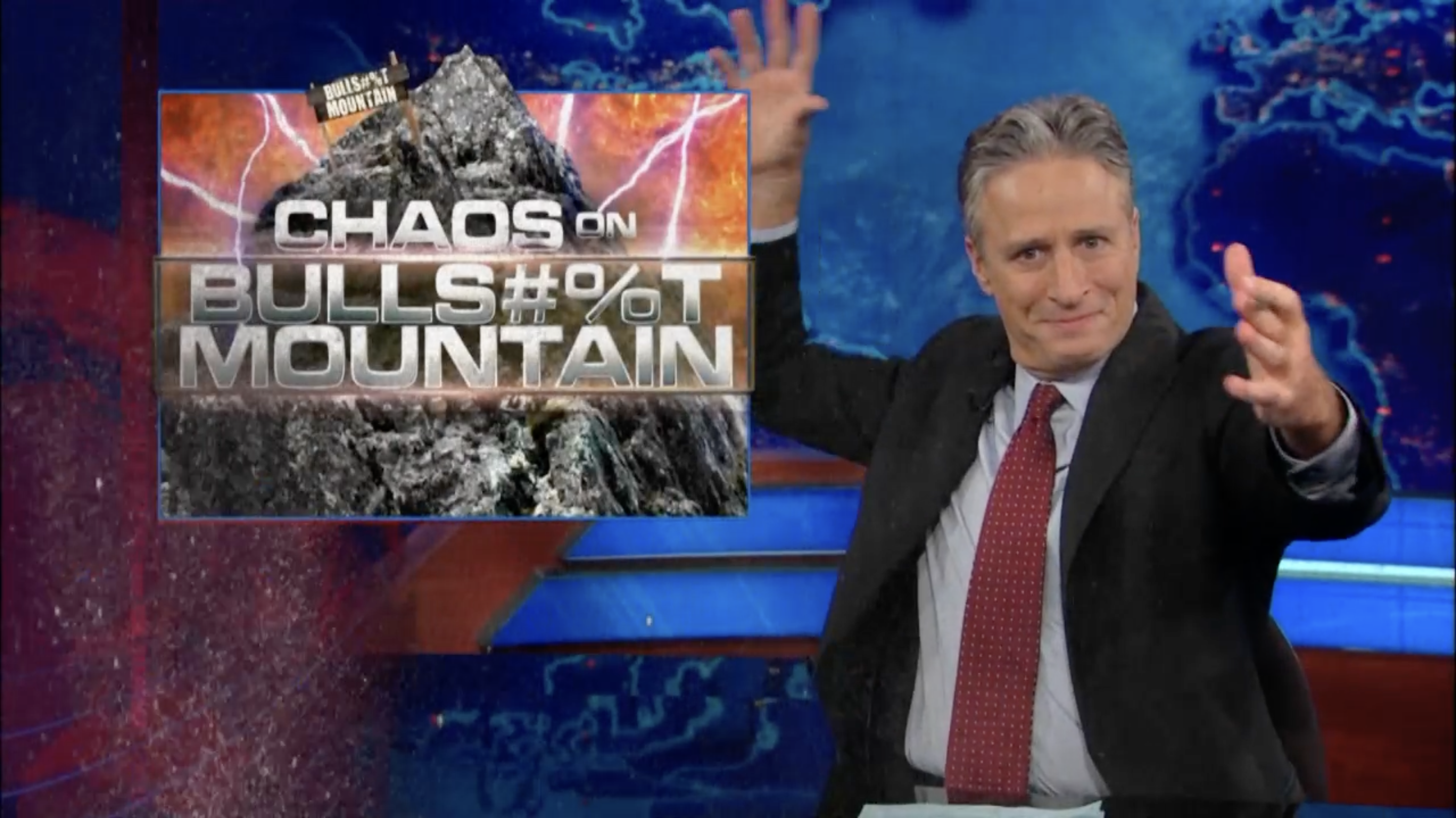 Jon Stewart introducing a segment on The Daily Show with the title 'Chaos on Bullshit Mountain'